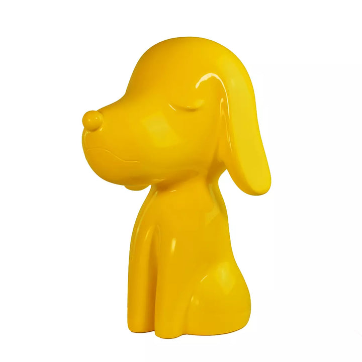 Lato Fronte statua gialla a forma di cane, con occhi naso e bocca. Sfondo bianco