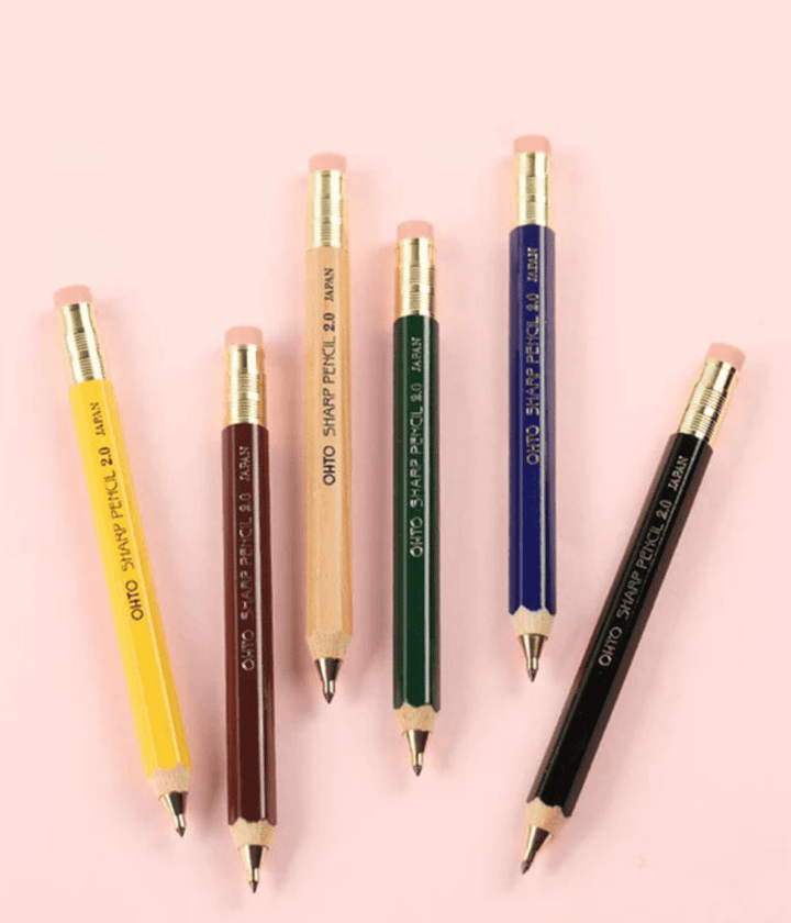 Matitoni con scritta Ohto. Giallo marrone, naturale, verde, blu, nero. Mina grigia.  Sfondo rosa
