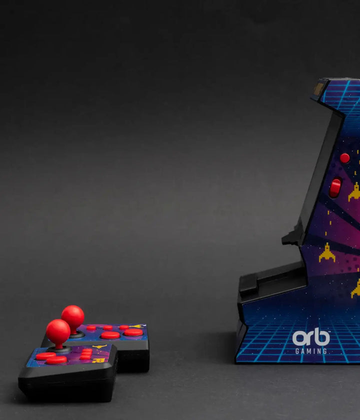 Controller con pulsanti rossi e Mini Arcade appoggiati sul tavolo grigio. Scritta Orb laterale bianca. 