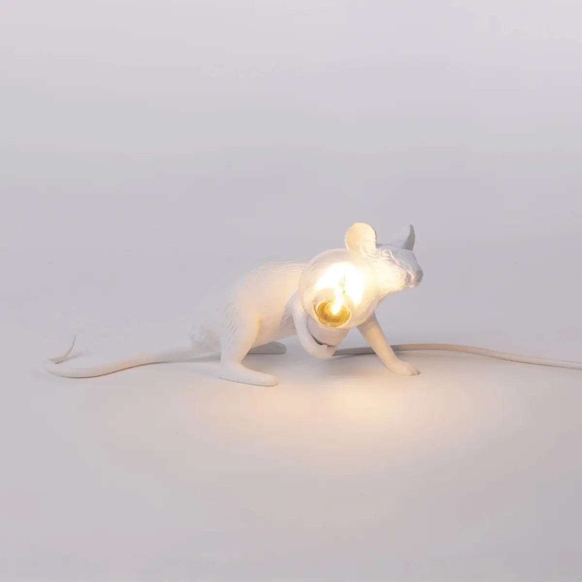 Lampada in resina bianca a forma di topo che tiene in mano una lampadina accesa. Sfondo bianco 
