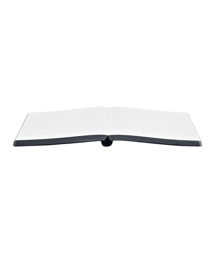 Notebook aperto a libro con bordo a puntini nero e argento su sfondo bianco.