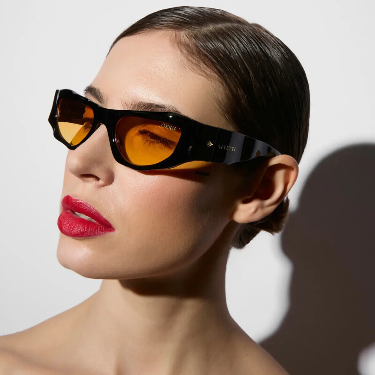 Modella che indossa gli occhiali da sole della collaborazione Okkia X Seletti nel modello Colorado Nero con lenti gialle