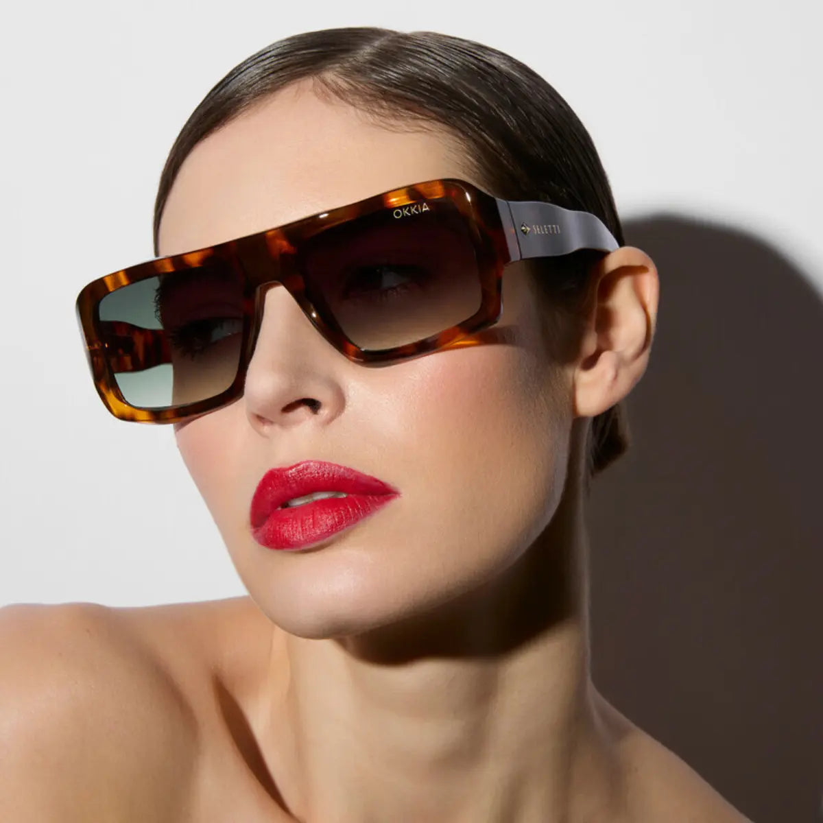 Modella che indossa gli occhiali da sole nel modello Kansas Havana con lente verde della collaborazione Okkia x Seletti