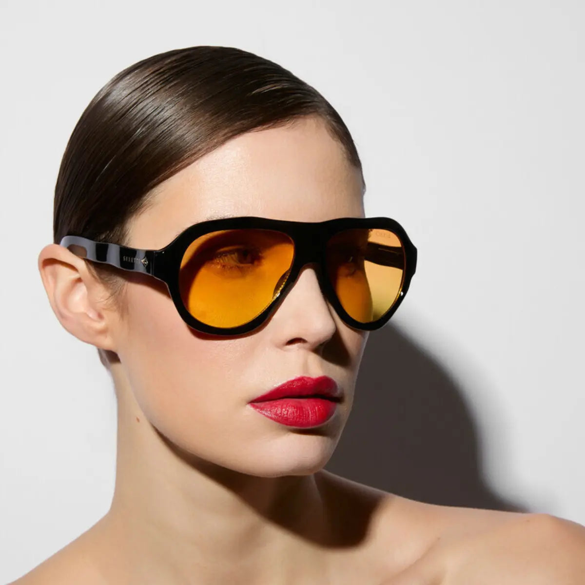 Modella che indossa gli occhiali della collaborazione okkia x Seletti nel modello Florida Nero con lenti gialle