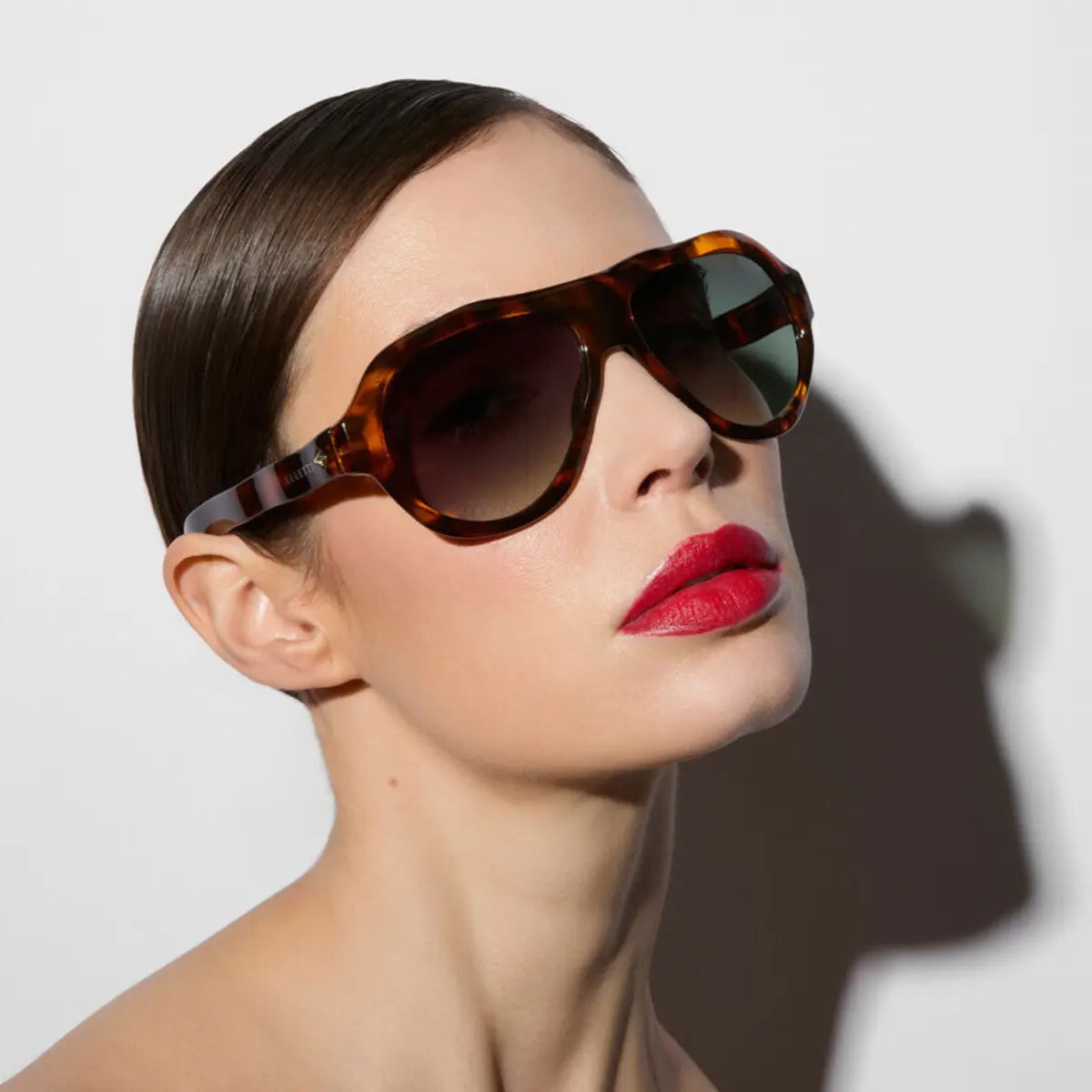 Modella che indossa gli occhiali della collaborazione okkia x Seletti nel modello Florida Havana con lenti verdi 
