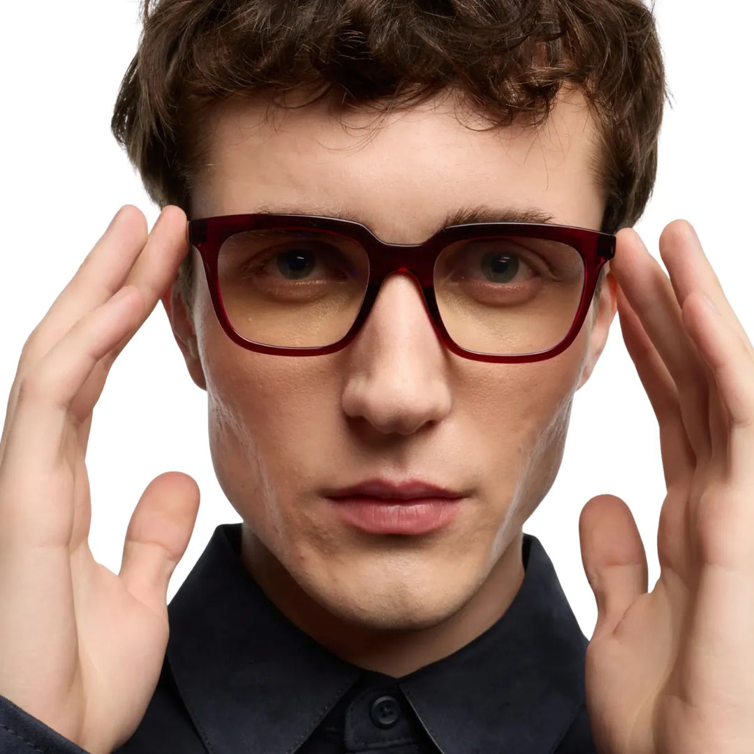 Uomo che indossa occhiale da lettura protezione luci blu montatura bordeaux lucida. 