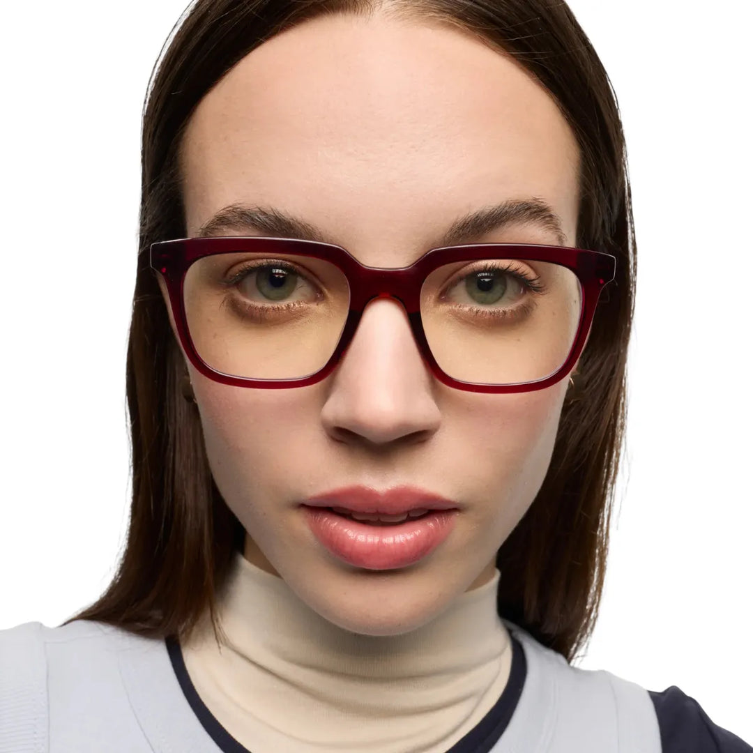 Donna che indossa occhiale da lettura protezione luci blu montatura bordeaux lucida.