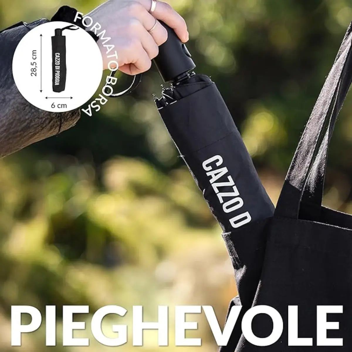 Mano che mette l'ombrello cazzo di pioggia nero chiuso dentro una borsa nera. Sfondo giardino. Scritta pieghevole bianca e cerchio in alto a sinistra con misure ombrello da chiuso