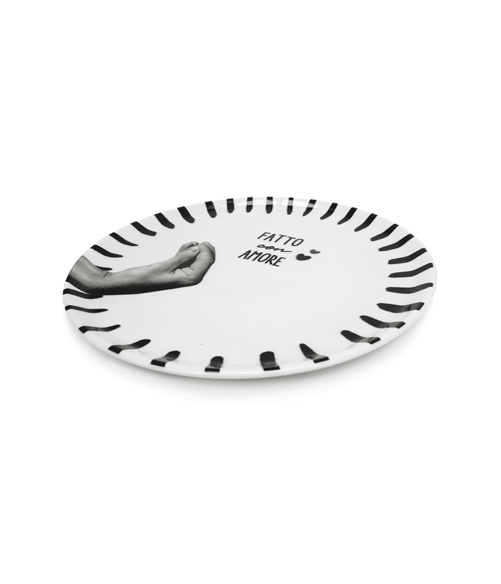 Piatto bianco con  bordo decorato nero. Mano grigia e scritta centrale nera. Sfondo bianco