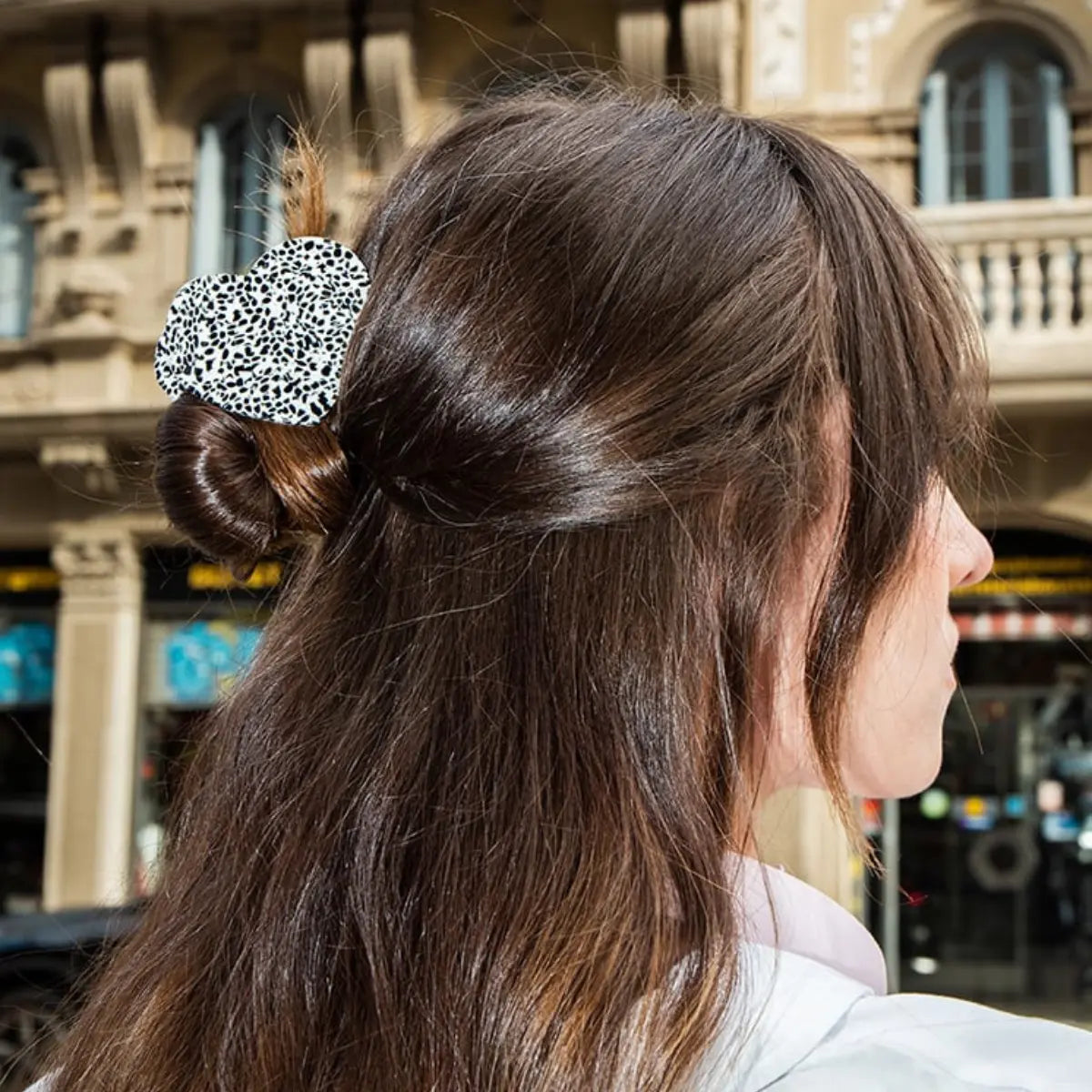 Pinza per capelli a forma di cuore con puntini bianchi e neri indossata su capelli di media lunghezza