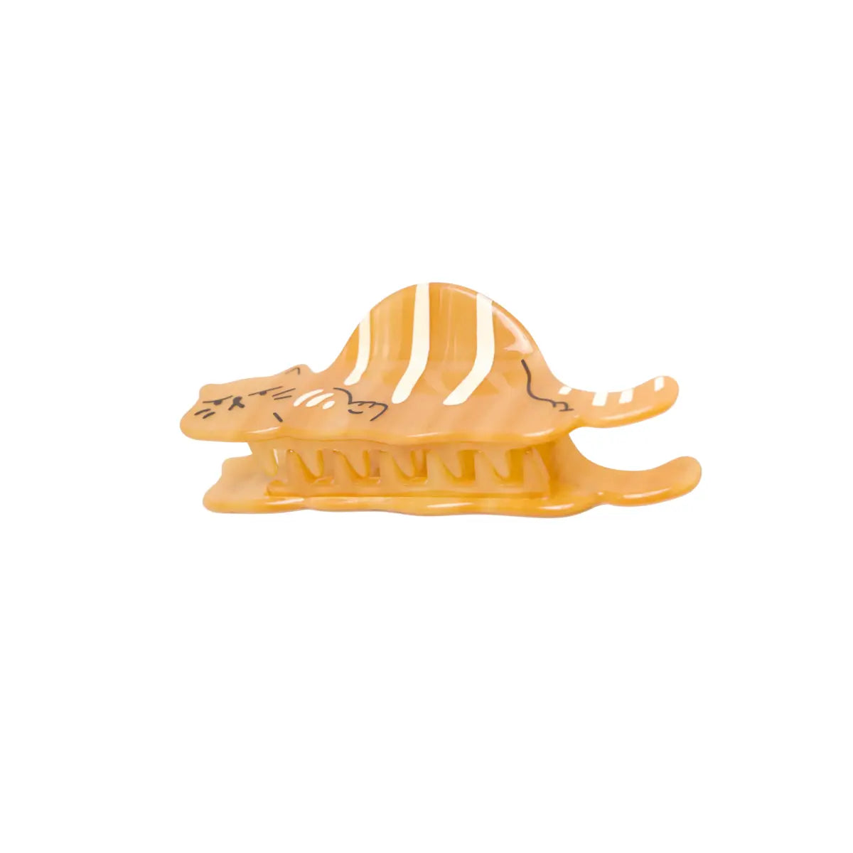 Pinza per capelli a forma di gatto rosso con le righe bianche sulla schiena e sulla coda. Il gatto viene rappresentato con un muso arrabbiato. La pinza è vista da sotto per far vedere i destini. Lo sfondo dell'immagine è bianco 