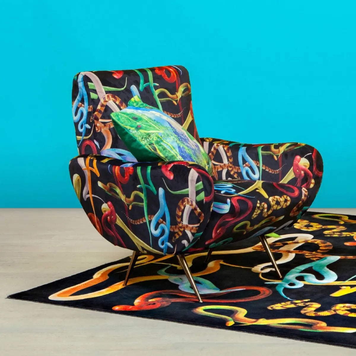 Poltrona Seletti tela nera con serpenti di diversi colori. Appoggiata su tappeto con lo stesso stile.