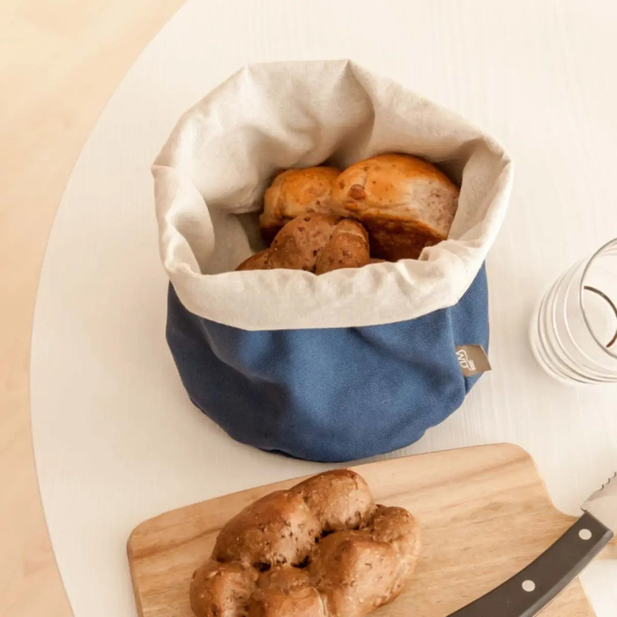 Sacchetto porta pane blu con il pane all'interno sulla tavola 