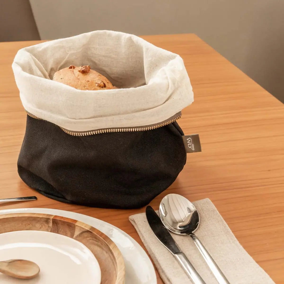 Sacchetto porta pane blu con il pane all'interno sulla tavola 