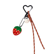 Portachiavi con ciondolo fragola rossa, perla bianca e corda intrecciata. gancio nero a forma di cuore. Sfondo bianco 
