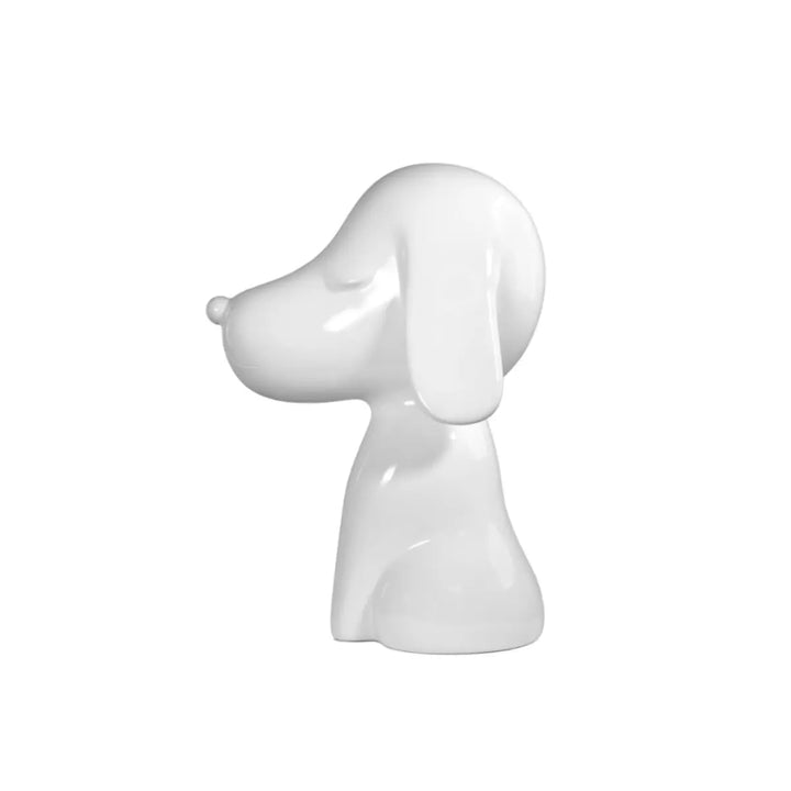 Profilo statua bianca a forma di cane, con occhi naso e bocca. Sfondo bianco