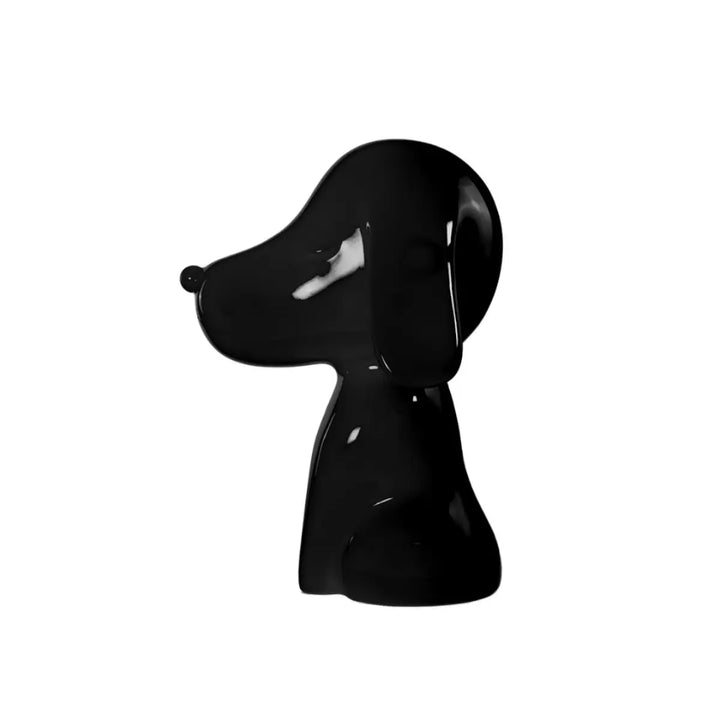 Profilo statua nera a forma di cane, con occhi naso e bocca. Sfondo bianco