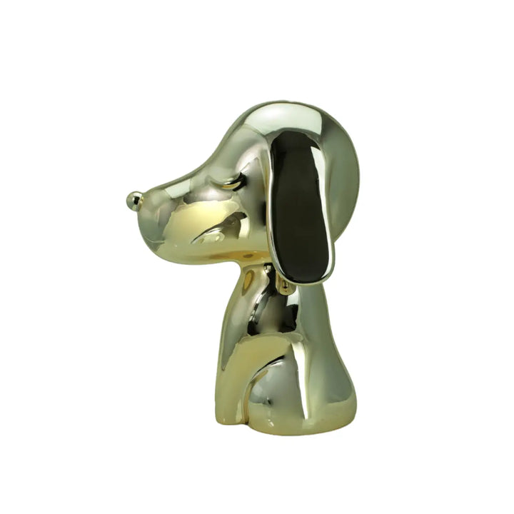 Profilo statua oro a forma di cane, con occhi naso e bocca. Sfondo bianco