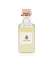 Una bottiglia in vetro trasparente con fragranza beige. Etichetta Chiara Firenze, tappo sughero.