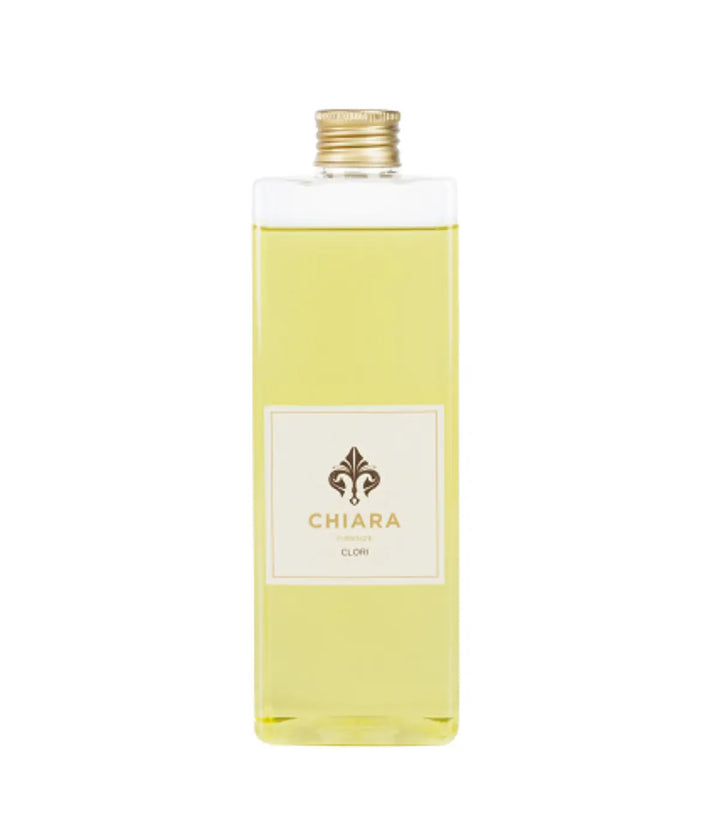 Una bottiglia vetro trasparente con fragranza gialla. Etichetta Chiara Firenze Clori. Sfondo bianco