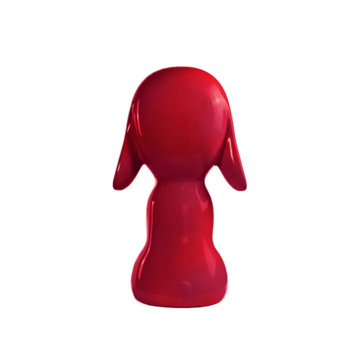 Retro statua fuxia a forma di cane, con occhi naso e bocca. Sfondo bianco