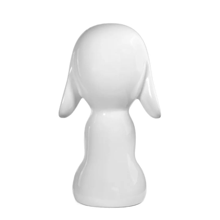 Retro statua bianca a forma di cane, con occhi naso e bocca. Sfondo bianco