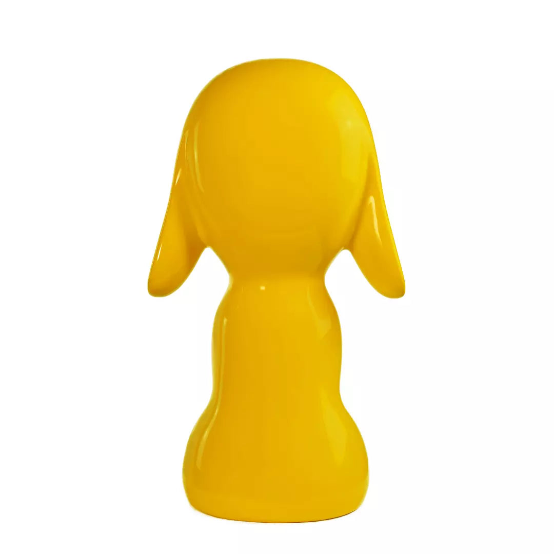 Retro statua gialla a forma di cane, con occhi naso e bocca. Sfondo bianco