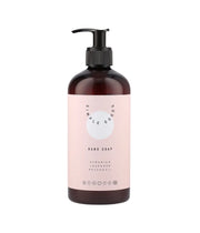 Porta sapone marrone con etichetta rosa. Scritte nere Simple Goods, Hand Soap.  Sfondo bianco