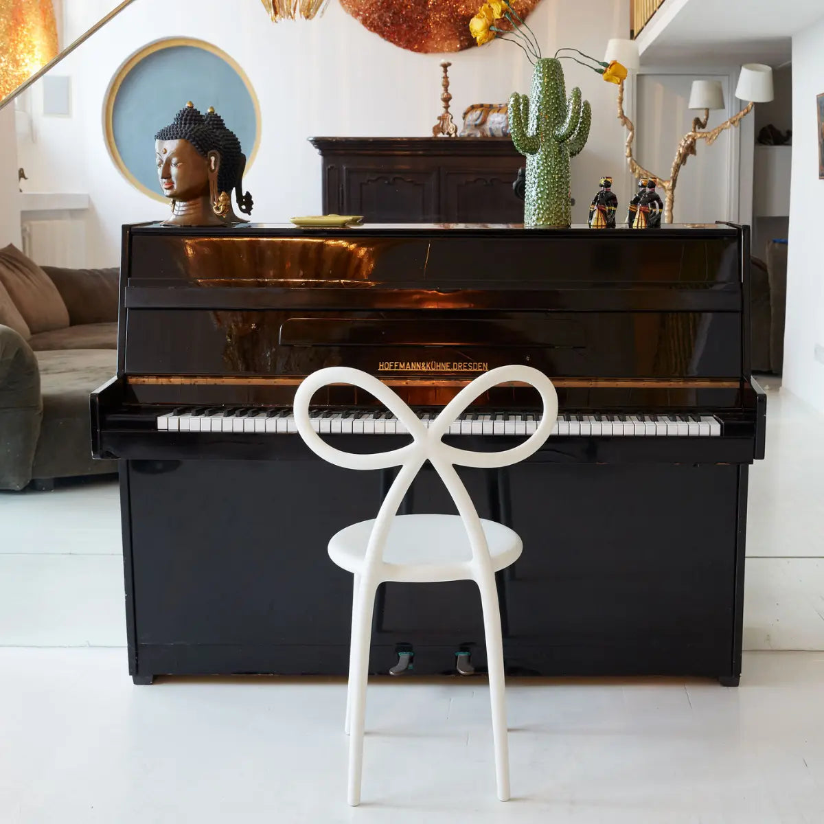 Sedia bianca con schienale a fiocco posizionata davanti ad un pianoforte