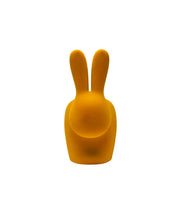 Sedia a forma di coniglio in velluto color senape. Immagine su sfondo bianco