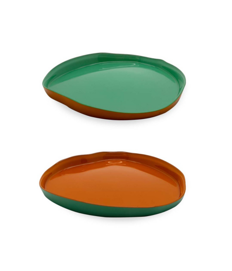 Due piatti in vetro uno verde fuori, arancione dentro. Uno arancione fuori, verde dentro. Fondo bianco