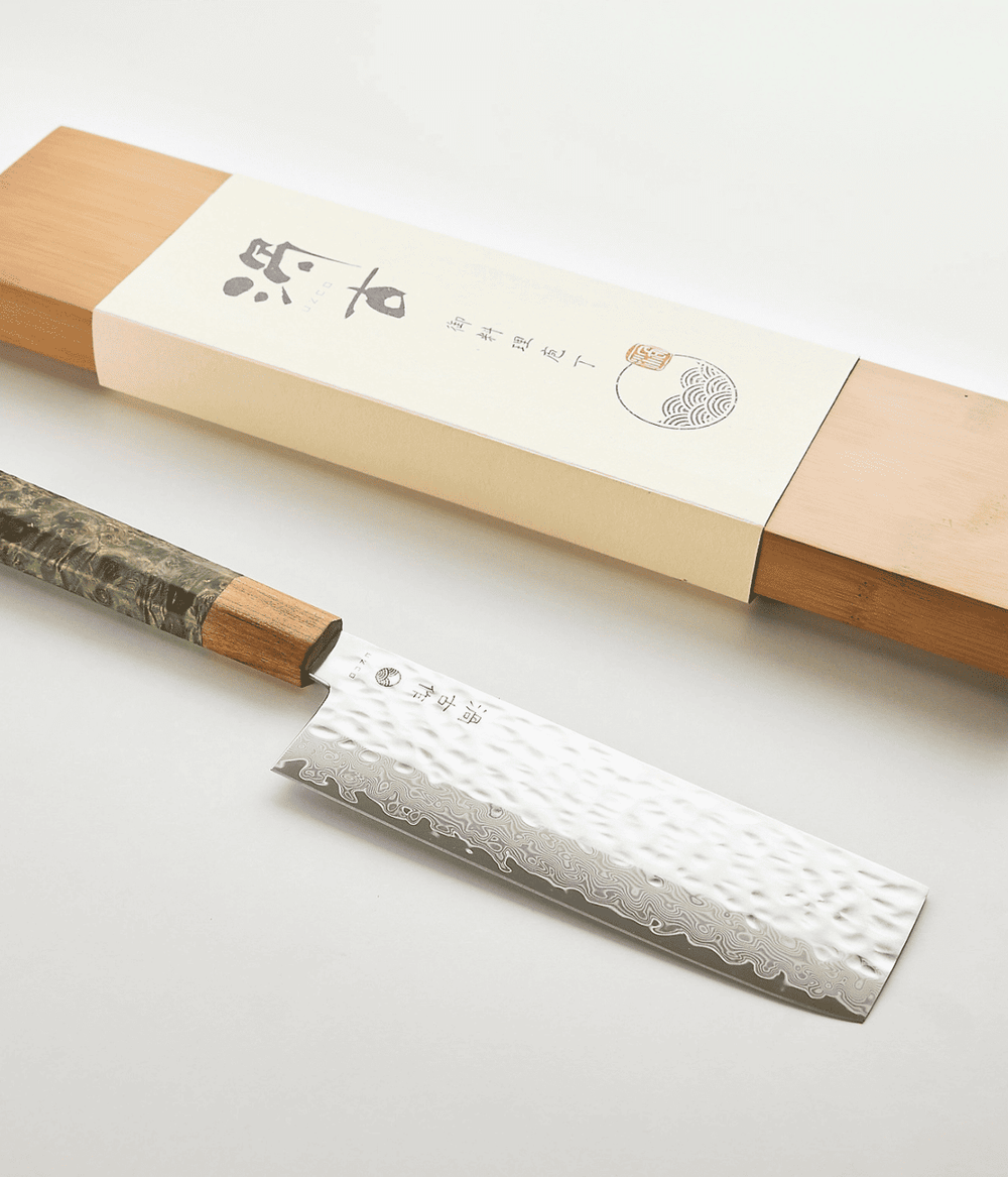 Lama con scritta Giapponese e lavorazione Tsuchime. Scatola in legno. Immagine su sfondo bianco.