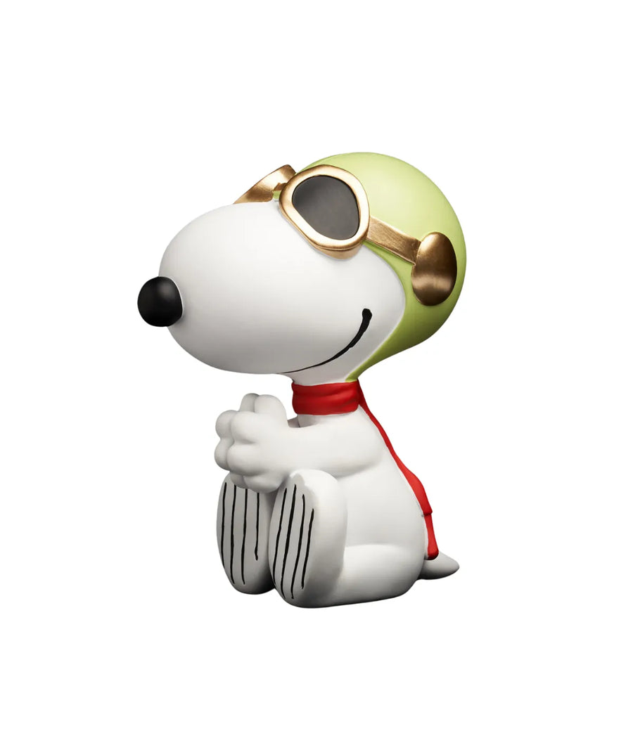 Snoopy bianco Aviator seduto. Caschetto verde e occhiali color oro. Sciarpa rossa. Sfondo bianco.