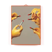 Specchio medio con grafica iconica di cinque mani che tengono rossetti. Cornice rossa di plastica con supporto. Sfondo bianco 