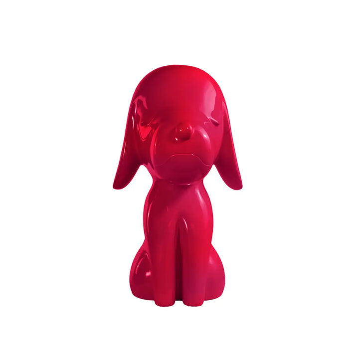 Una statua fuxia a forma di cane, con occhi naso e bocca. Sfondo bianco