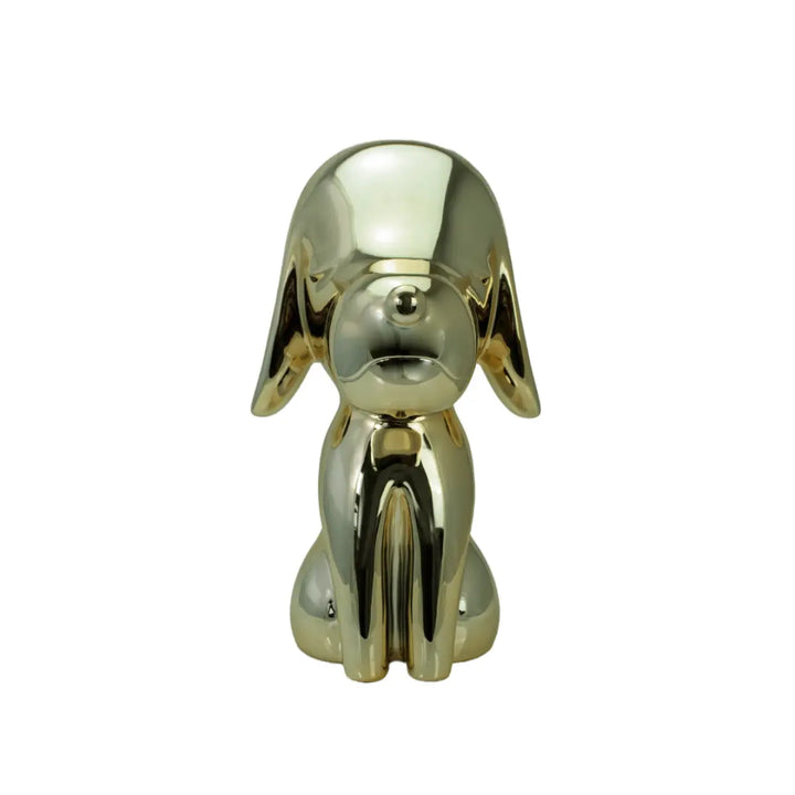 Una statua oro a forma di cane, con occhi naso e bocca. Sfondo bianco