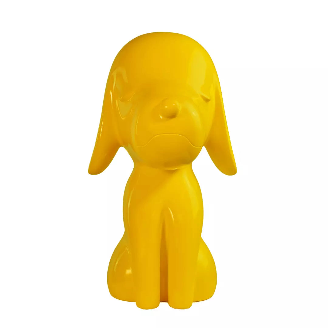 Una statua gialla a forma di cane, con occhi naso e bocca. Sfondo bianco