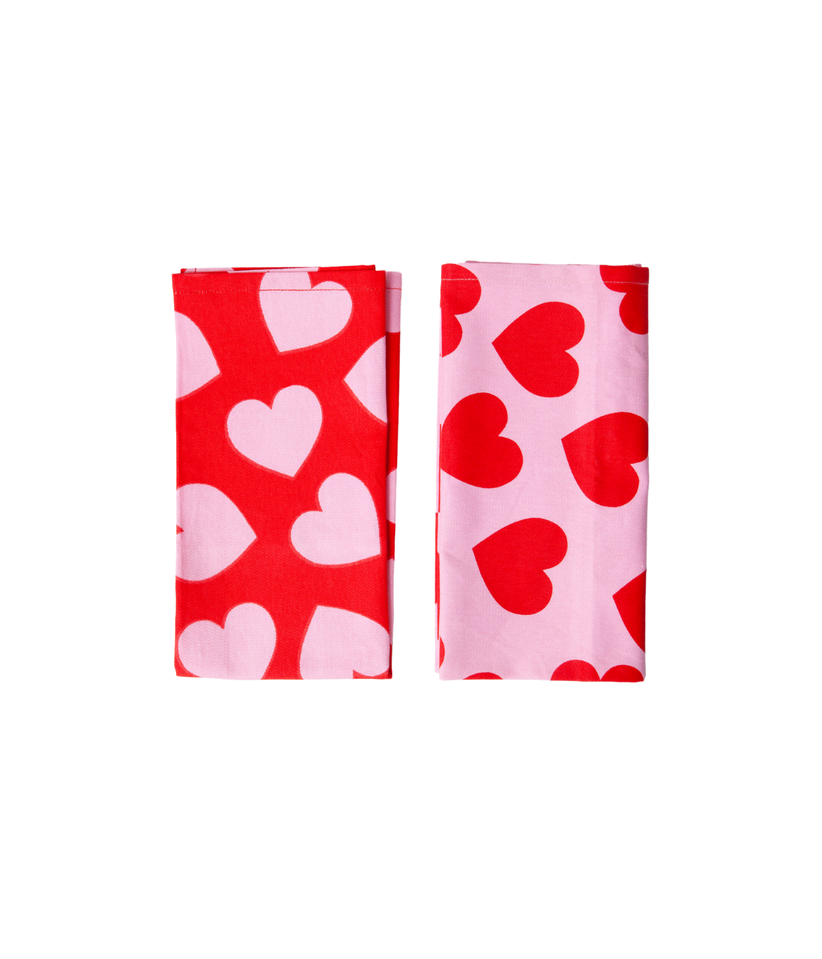 Due strofinacci uno rosa con cuori rossi e uno rosso con cuori rosa piegati. Sfondo bianco