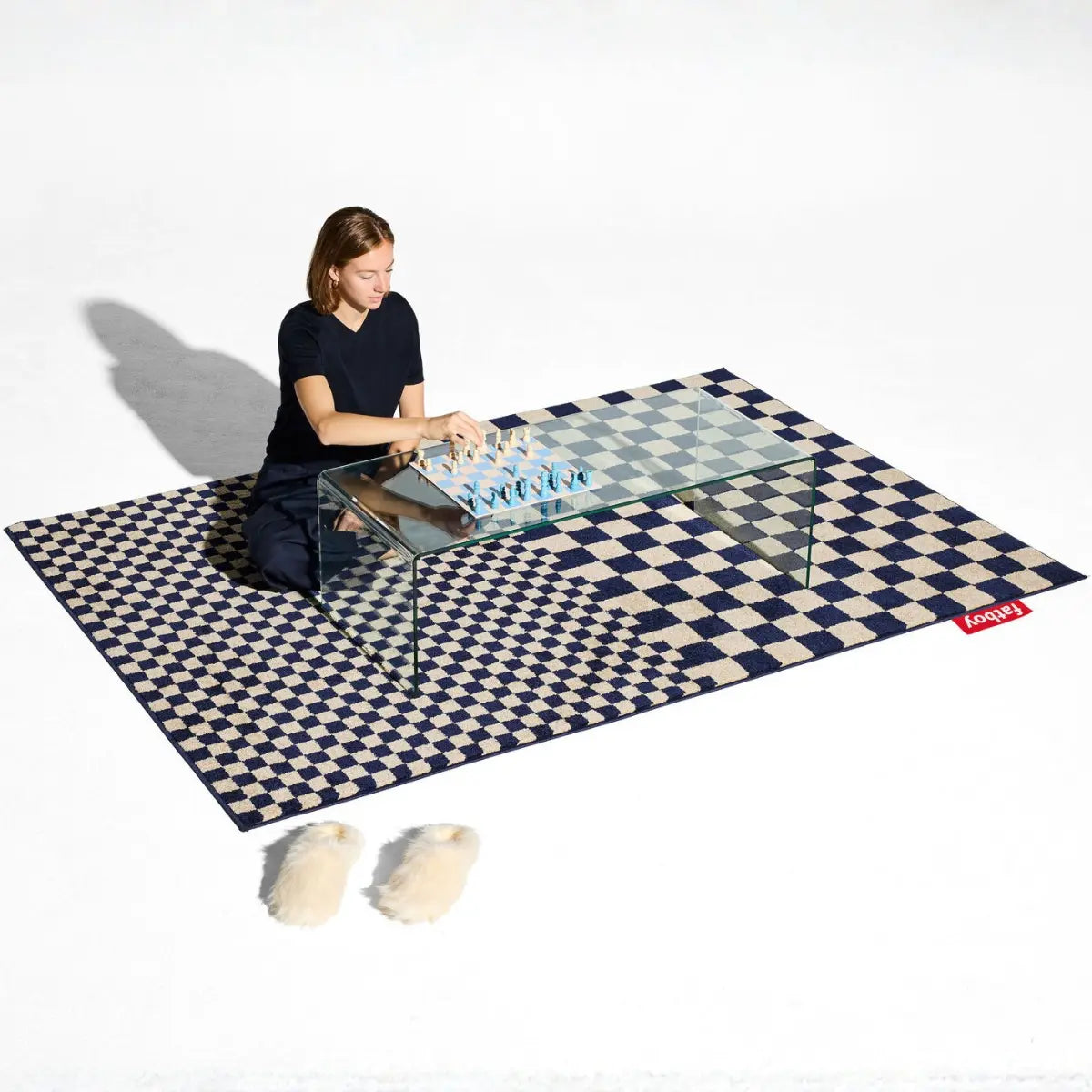 Foto ambientata Tappeto Petit Square Affair a quadretti blu e beige con donna e scacchi