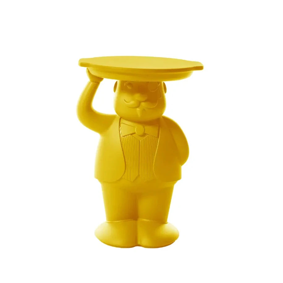 Tavolino giallo che rappresenta un maggiordomo con un braccio alzato che sostiene un vassoio che funge da appoggio del tavolino. Sfondo bianco