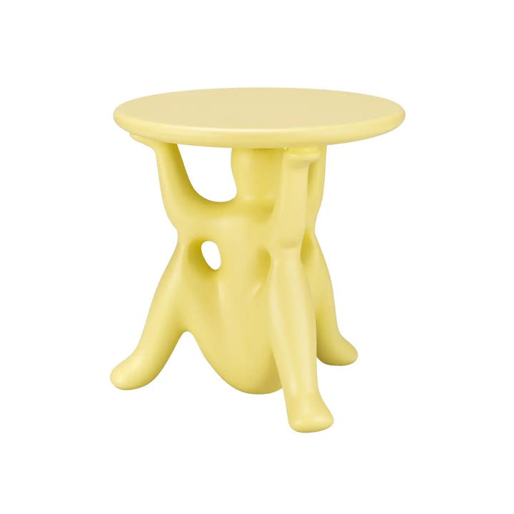 Tavolino giallo con struttura particolare costituita da tre geni che sorreggono il piano rotondo