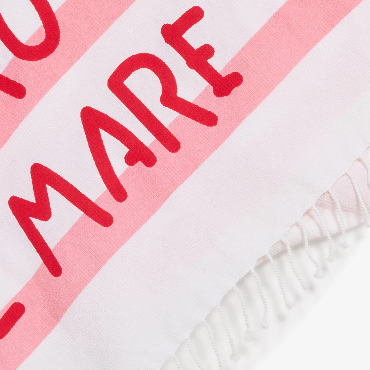 Dettaglio del telo mare a righe bianco e rosa con scritta rossa