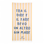 Telo mare con sfondo a righe bianche e gialle e scritta blu "Tra il dire e il fare bevo un altro gin mare"