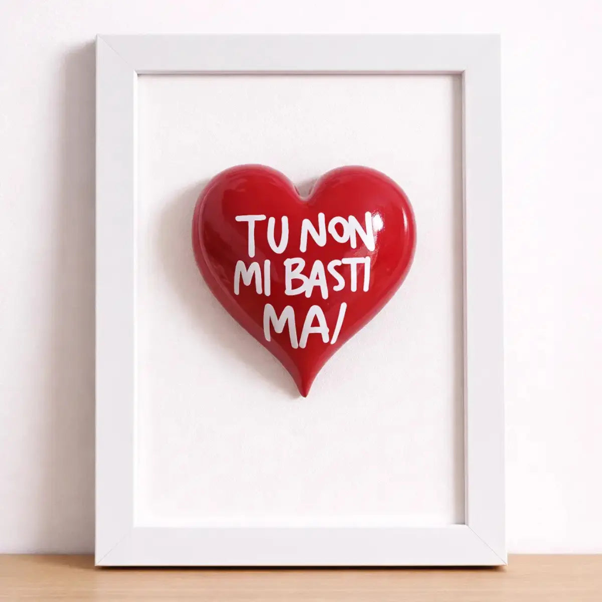 Quadretto CuoreAmore fatto a mano in Italia. Ha una cornice in legno bianca e un cuore in ceramica rosso con una scritta  