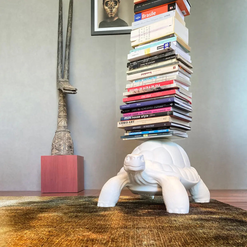 Libreria verticale con base a forma di tartaruga Qeeboo posizionata in un salotto
