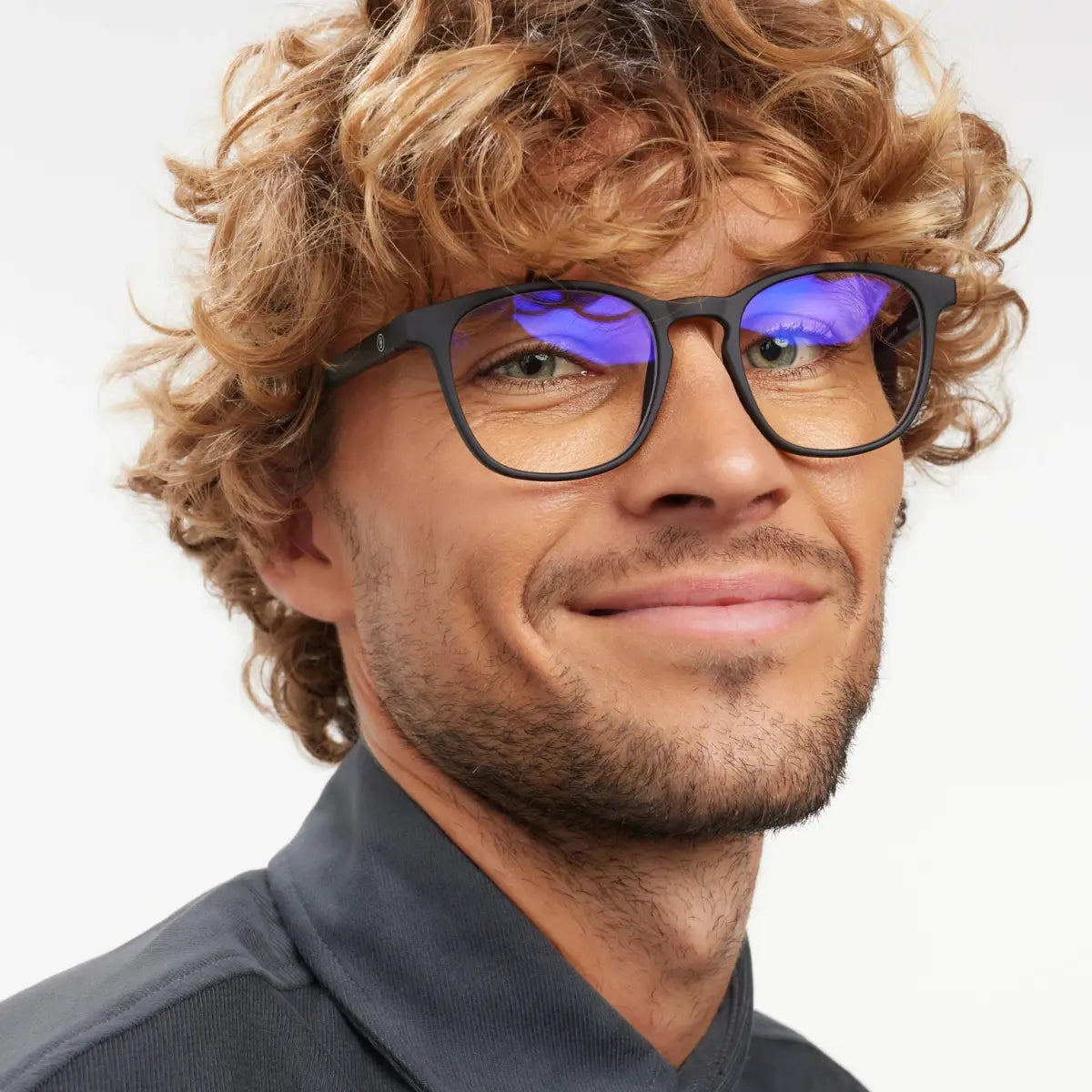 Occhiale finitura nera opaca, con protezione luci blu indossato da uomo biondo