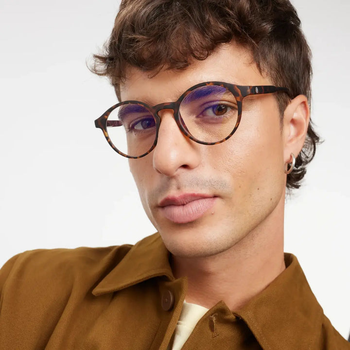 Occhiale marrone design tartaruga finitura opaca, con protezione luci blu indossato da uomo moro.