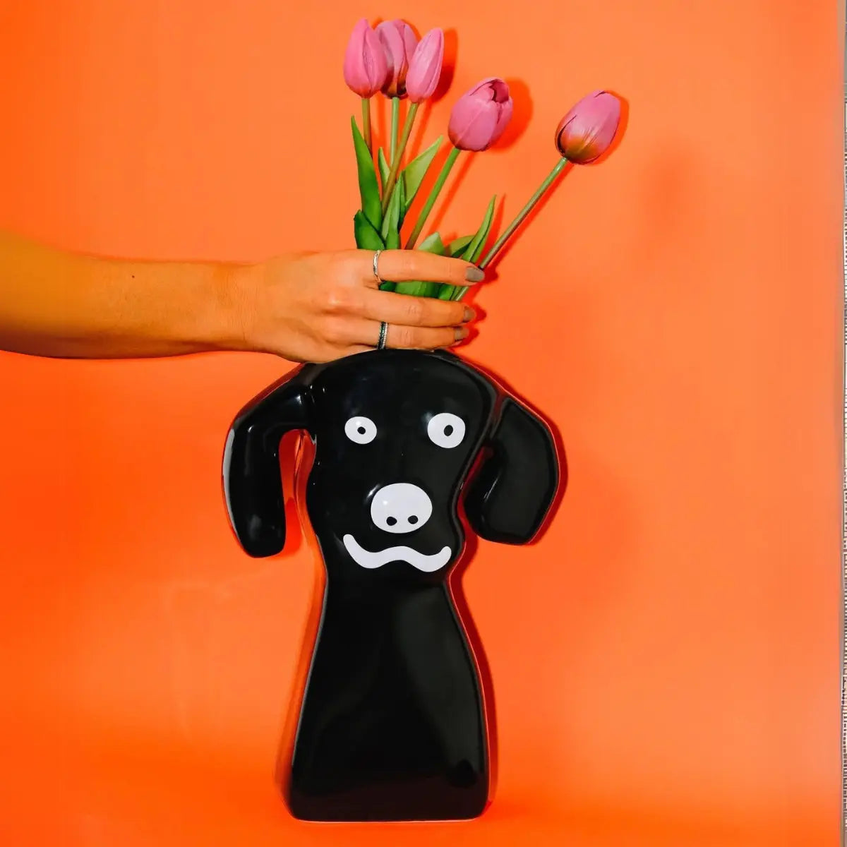 Vaso a forma di cane nero con tulipani rosa