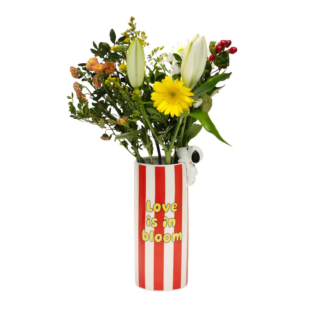 Vaso con fiori di Snoopy a righe bianche e rosse e scritta in gialla love is in bloom