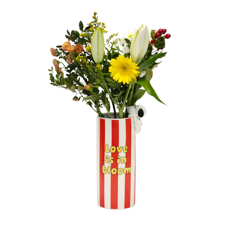 Vaso con fiori di Snoopy a righe bianche e rosse e scritta in gialla love is in bloom